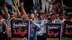 Palestinian demonstrators hold slogans reading in Arabic “normalisation is betrayal” during a demonstration in Gaza City  against a US-brokered deal between Israel and the UAE to normalise relations. Photograph:  Mohammed Abed/AFP/via Getty Images