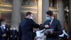 French president Emmanuel Macron  elbow bumps after handing over a Welcome to French Citizenship booklet to a new French citizen during a ceremony to celebrate the 150th anniversary of the proclamation of the republic at the Pantheon in Paris on Friday. Photograph: Julien De Rosa/AFP/Getty