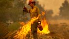 Mormon Lake Hotshots firefighter Sara Sweeney uses a drip torch to set a backfire to protect mountain communities from the Bobcat Fire in the Angeles National Forest  in California. Photograph: David McNew/Getty Images