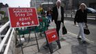  Pedestrians pass a social distancing sign on Waterloo Bridge in London, Britain, on Friday. Photograph: Neil Hall/EPA