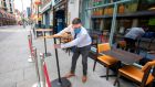 An employee sets out tables for customers outside of a pub in Dublin on Friday. Photograph:   Paul Faith/AFP