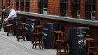 A man sits outside an empty pub in Dublin’s city centre, where many shops and businesses are closed. Photograph: Brian Lawless/PA Wire
