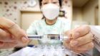 A nurse shows a flu vaccine at a clinic in Seoul, South Korea. Photograph: Yonhap/EPA