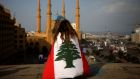 A Lebanese anti-government protester draped in a national flag sits overlooking the Mohammed al-Amin mosque and the Martyrs square in Beirut on November 14th, 2019. Photograph:  Patrick Baz/AFP via Getty Images
