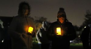 People at a candlelit vigil in the Llewellyn estate in Ballinteer, south Dublin, following the discovery of bodies of a woman and two young children. Photograph:  Brian Lawless/PA Wire 