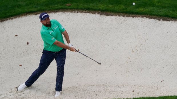 Lowry splashes out of a bunker on the 13th. Photo: Chris Carlson/AP Photo