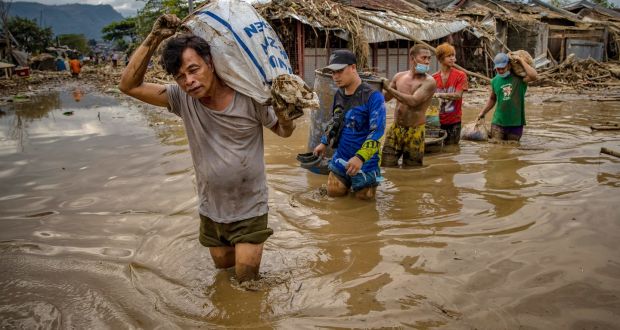  Residents carry their belongings as they wade through muddy floodwater that submerged a village after Typhoon Vamco hit on Saturday  in Rodriguez, Rizal province, Philippines. Photograph:  Ezra Acayan/Getty Images