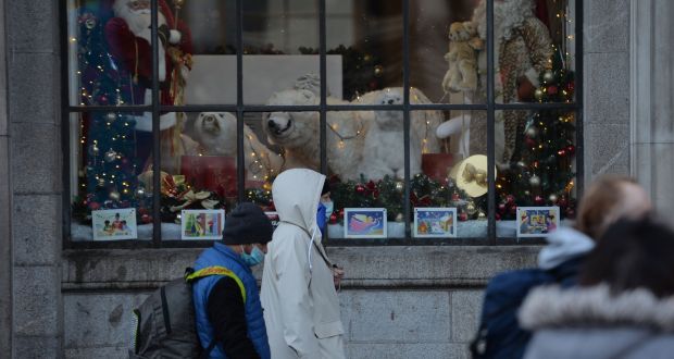  Mask-wearing people pass Christmas windows at the GPO in Dublin on Saturday. Photograph: Alan Betson