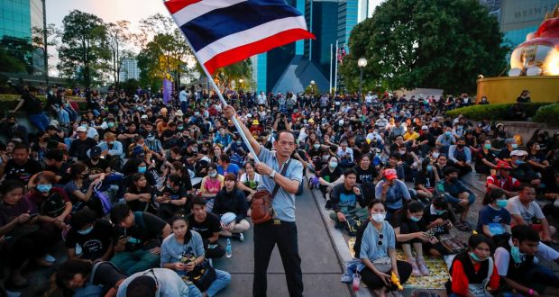 An anti-government protester waves a large Thai  flag during a protest calling for monarchy reform at the Siam Commercial Bank headquarters in Bangkok on November 25th. Photograph: Diego Azubel/EPA