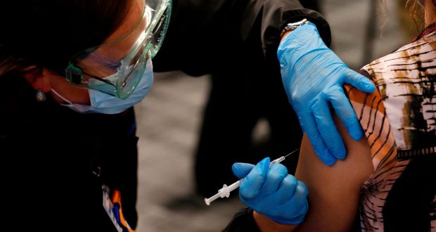 Healthcare workers receive their first dose of the Pfizer/BioNTech Covid-19 vaccine in Michigan. Photograph: Jeff Kowalsky/AFP via Getty