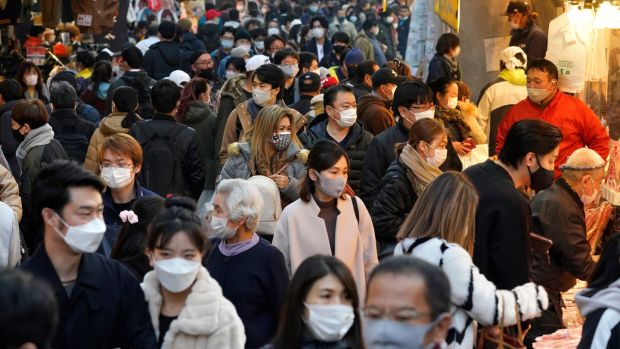 Shoppers wearing protective masks crowd the Ameyoko Street for a yearend shopping in preparation for the New Year at Ueno in Tokyo. Photograph: Kimimasa Mayama/EPA