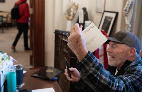 Another Trump supporter sits inside the office of Speaker of the House Nancy Pelosi. Photograph: Saul Loeb/AFP via Getty Images
