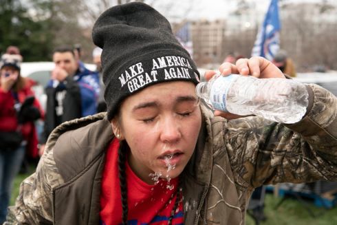 A supporter of Trump puts water in her eyes after US Capitol police officers deployed tear gas at demonstrators outside of the US Capitol on Wednesday. Photograph: Jose Luis Magana/AP
