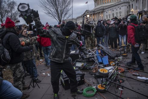 Demonstrators destroy broadcast video equipment outside the Capitol building after they earlier swarmed into the building in Washington. Photograph: Victor J Blue/Bloomberg
