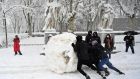 Young people roll a giant snowball in Madrid on Saturday. Photograph: Gabriel Bouys/AFP via Getty