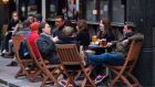 Drinkers outside a pub in Soho, London, last October. Outdoor hospitality in England is due to open on April 12th under the new plan. Photograph: Dominic Lipinski/PA Wire 