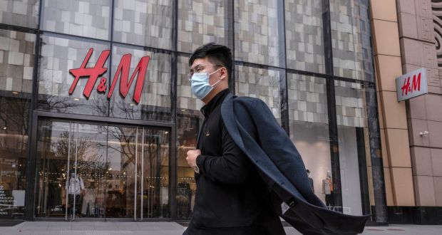 A man walks by an H&M clothing store at a shopping area  in Beijing, China. Chinese state media and social networking platforms called for boycotts of major Western brands, including H&M, after their raising of human rights issues. Photograph: Kevin Frayer/Getty Images