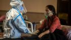 A healthcare worker assists a patient with Covid-19 at a hospital in Delhi, India. Photograph: Atul Loke/The New York Times