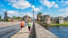 Running  in  Limerick, with King John’s castle in the background. The city has  concrete goals when it comes to energy usage as it undergoes the transition to a clean-energy city by 2050