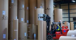 An employee operates a forklift truck to stack rolls of paper in the reel store at  Smurfit Kappa in the UK. Photographer: Jason Alden/Bloomberg