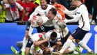 England captain  Harry Kane is mobbed by his team-mates after scoring with a rebound after his penalty kick was saved by Denmark goalkeeper Kasper Schmeichel during the Euro 2020 semi-final at Wembley Stadium. Photograph: Andy Rain/EPA