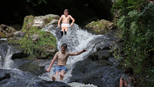 Friends Daithi Dignam and Ben Noone (centre) taking the cooling plunge in the Shankill River, Manor Kilbride, Dublin on Tuesday. Photograph: Nick Bradshaw / The Irish Times
