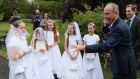 Taoiseach Micheál Martin meets 3rd class pupils from St Brigid’s Girls National School in Glasnevin (from left) Isabella Ryan (10), Ella Brereton (9), Charlotte Collins (9), Caoimhe Flanagan (10), and Faye Haverty (10), who made their First Holy Communion on Wednesday as a small group.  Photograph: Brian Lawless/PA Wire