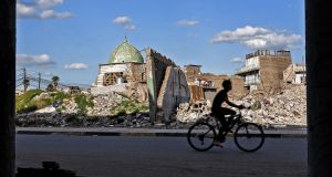 An Iraqi youth rides a bicycle past the Nuri mosque in the old town of  Mosul in March.  Photograph: Zaid al-Obeidi/AFP via Getty Images