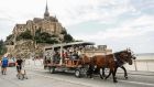A man drives a tourists shuttle in front of the Mont-Saint-Michel, in Normandy, France. Cinemas, museums and sports venues began asking visitors to furnish proof of Covid-19 vaccination or a negative test. Photograph: Getty Images