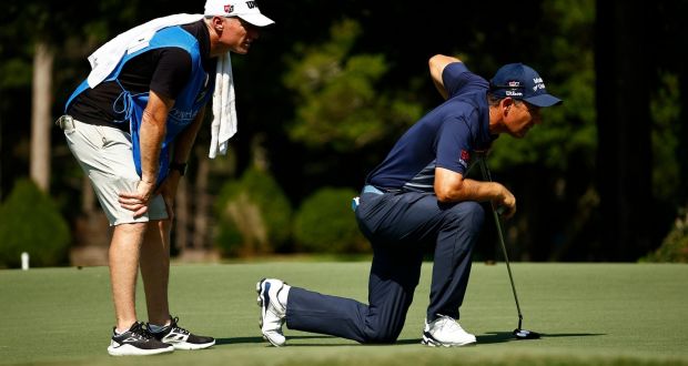 Pédraig Harrington of Ireland and caddie Ronan Flood line up a putt during the first round of the Wyndham Championship at Sedgefield Country Club. Photo: Jared C. Tilton/Getty Images