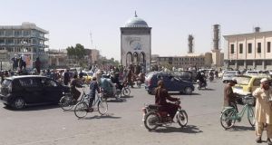 Afghans look on on Friday as Taliban militants gather around the main square after taking control of Kandahar, Afghanistan’s second biggest city. Photograph: EPA