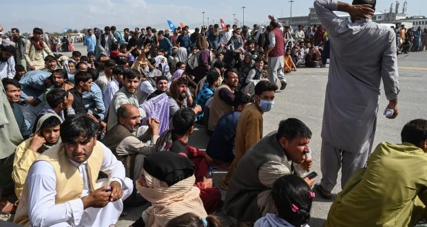 People hopeful of evacuation sit on the tarmac at Kabul airport in Kabul, Afghanistan, on Monday, after a stunningly swift end to the country’s 20-year war. Photograph: Wakil Kohsar/AFP/Getty 