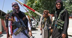 Taliban fighters stand guard along a roadside in Kabul after the swift end to Afghanistan’s 20-year war. Photograph: Wakil Kohsar/AFP via Getty Images