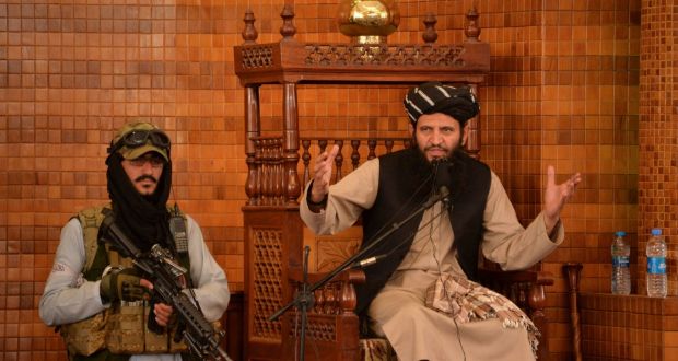 An Imam speaks next to an armed Taliban fighter during Friday prayers at the Abdul Rahman Mosque in Kabul. Photograph: AFP via Getty Images