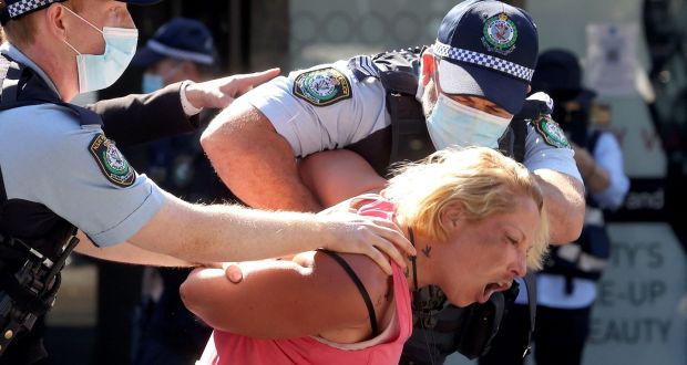  Police officers detain a woman  in Sydney at an anti-lockdown protest. Photograph: David Gray/AFP via Getty Images