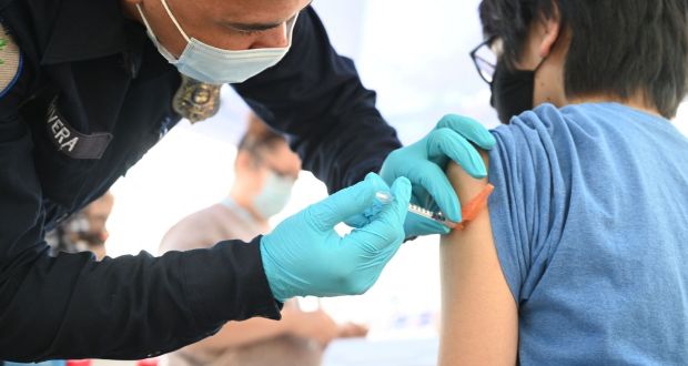 Brandon Rivera, a Los Angeles County emergency medical technician, gives a second does of Pfizer-BioNTech Covid-19 vaccine to Aaron Delgado, 16, at a pop up vaccine clinic in California last week. Photograph:   Robyn Beck/AFP
