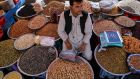 A roadside vendor selling dry fruits waits for customers at a market area in Kabul. Photograph:  Hoshang Hashimi/AFP via Getty Images