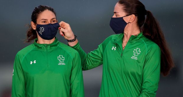 Eve McCrystal adjusts Katie-George Dunlevy face mask ahead of the gold medal ceremony for their win in the B time-trial at the Tokyo Paralympics. Photograph: Tommy Dickson/Inpho