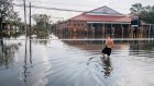 A man wades through flood water  in Jean Lafitte, a small town 20 miles south of New Orleans in  Louisiana. Photograph:  Brandon Bell/Getty Images