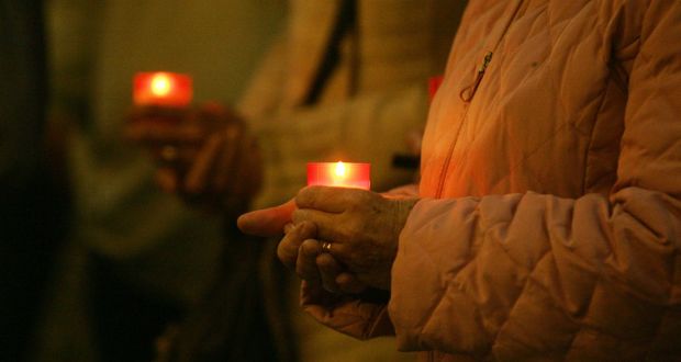 A woman holds a candle during a candelit vigil at College Green in Dublin on World Suicide Prevention Day remembering those lost to suicide. Photograph: Aidan Crawley