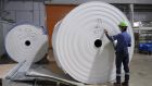 A worker checks a spool of recycled paper at a Corelex Shinei Co. toilet paper factory in Fuji, Shizuoka Prefecture, Japan. Photographer: Toru Hanai/Bloomberg