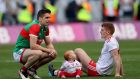 Tyrone’s Peter Harte, with his daughter Ava, and Mayo’s Lee Keegan sit  on the field  and  talk quietly after the match. Photograph: James Crombie/Inpho