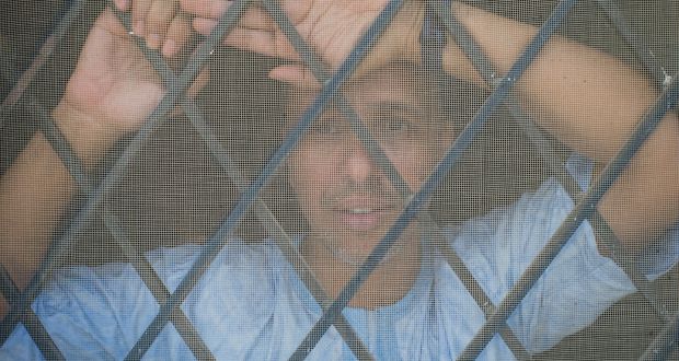 Mohamedou Ould Slahi, who underwent brutal interrogations while he was held at Guantánamo Bay 15 years ago, looks out a window of his home in Nouakchott, Mauritania. Photograph:  Btihal Remli/The New York Times