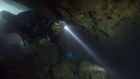 The Rescue. A diver swims through an underwater cave. Photograph: National Geographic