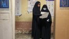 Women look at their ballot papers at a polling station in Iraq’s capital, Baghdad. Photograph: Ahmad al-Rubaye/AFP via Getty