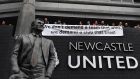 Newcastle United fans hang a banner abiove the statue of former manager Bobby Robson outside St James’ Park. Photo: Paul Ellis/Getty Images