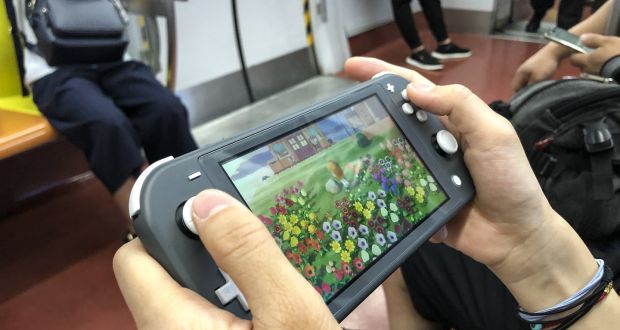A passenger on a Beijing train plays pandemic games hit Animal Crossing: New Horizons on a Nintendo Switch. Photograph: VCG via Getty