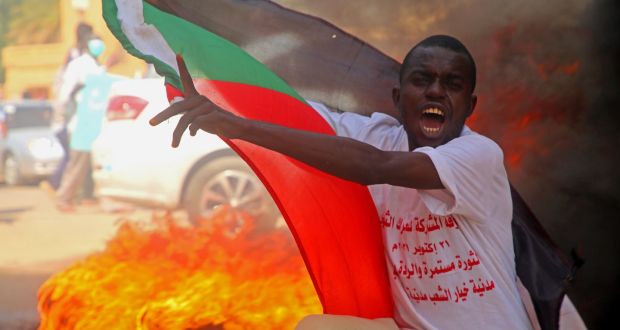 A protester holds a Sudanese flag and chants during demonstrations in support of the civilian government in Khartoum. Photograph: Mohammed Abu Obaid/EPA