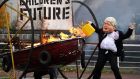 Cop26 opener: A performer from Ocean Rebellion dressed as UK prime minister Boris Johnson sets a prop boat alight on the banks of Glasgow’s river Clyde. Photograph: Andrew Milligan/PA