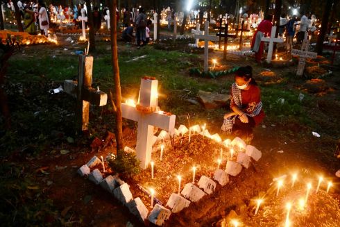 ALL SOULS: A Christian devotee pays her respects and offers prayers at the grave of a family member to mark All Souls Day at a cemetery in Dhaka, Bangladesh. Photograph: Munir Uz zaman/AFP/Getty 
